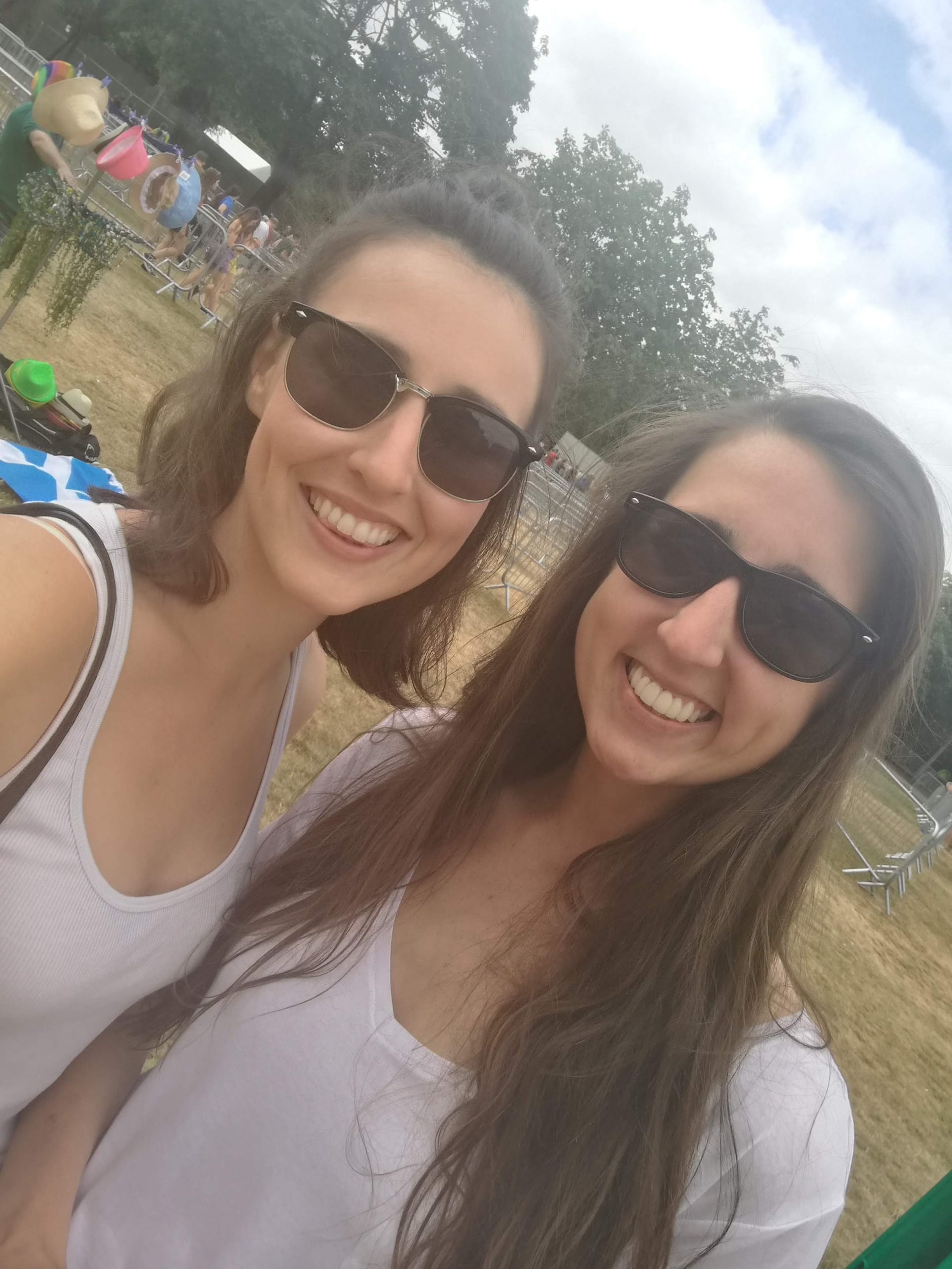 Image shows Harriet on the left with her sister to the right wearing sunglasses on a sunny day outside