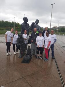 Image shows Amy and her colleagues posing in front of a statue, on their sponsored walk.